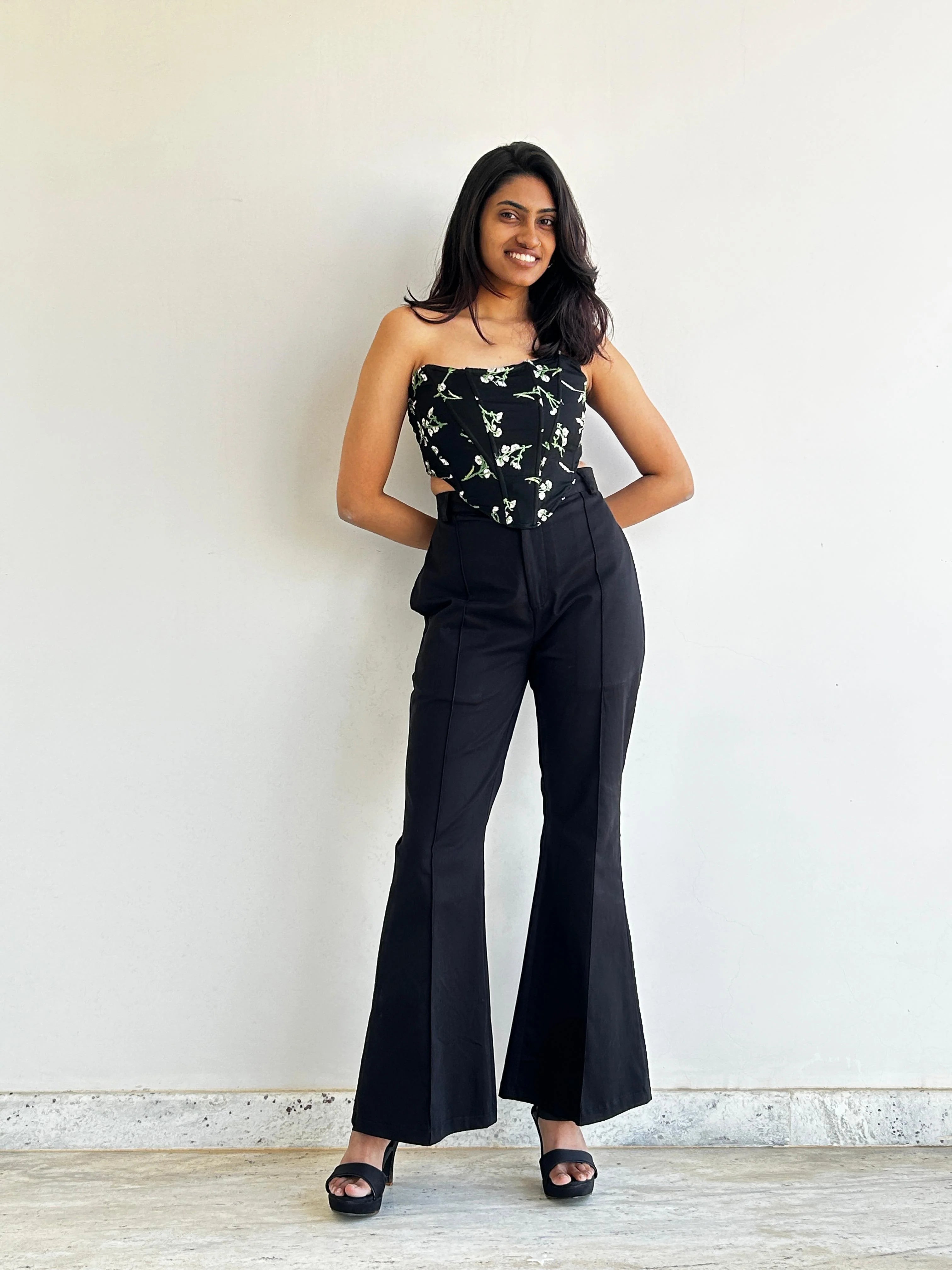 A woman wearing Black bootcut high waist formal trouser  along with a floral corset top | Black office pant | Asqeu